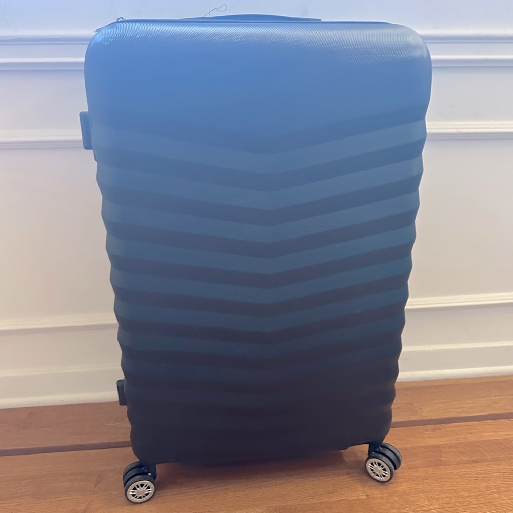 Black rolling suitcase (4 wheels). Used once for a shoot.